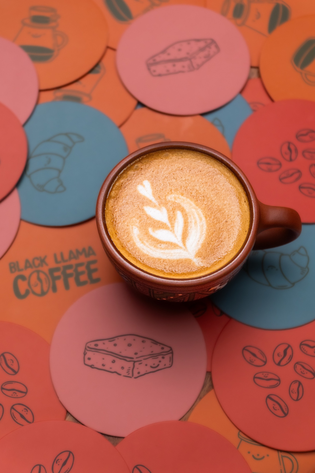 Latte art con stickers de Black Llama Coffee — mejor café en Cusco